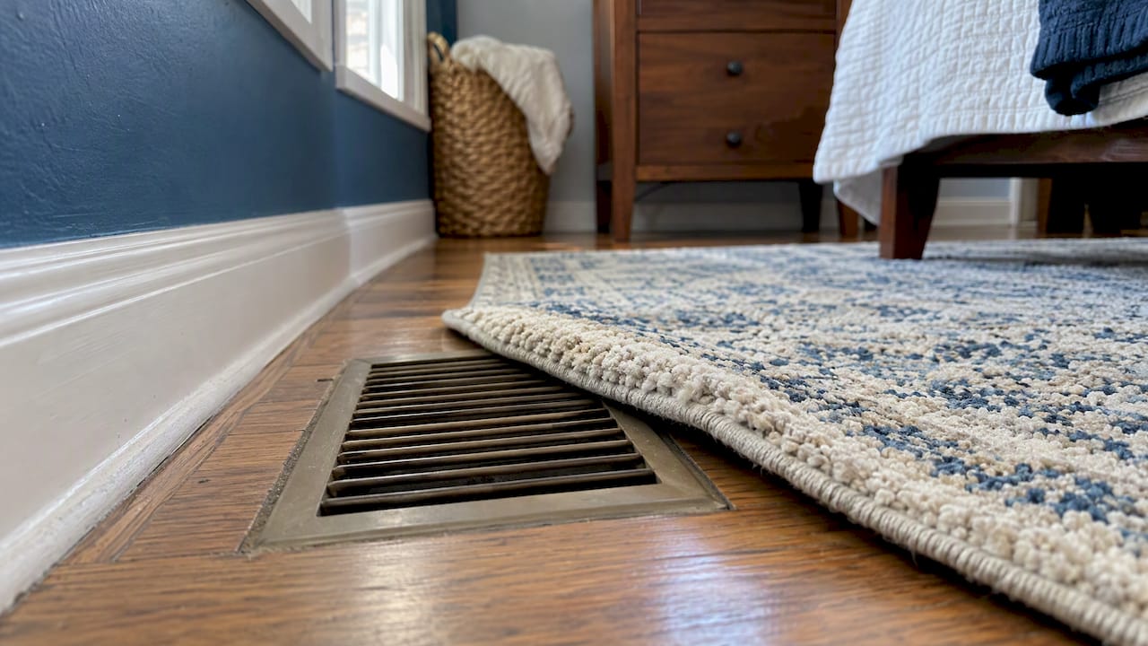 Bedroom rug partly covering a floor register