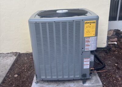 Outdoor AC condenser on a concrete pad beside a Sarasota home, serviced by AC Heroes.