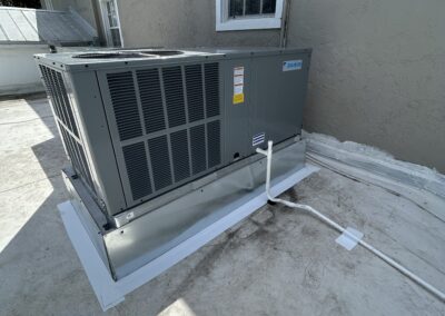 Weathered outdoor AC unit before replacement, sitting against a stucco wall in Bradenton.